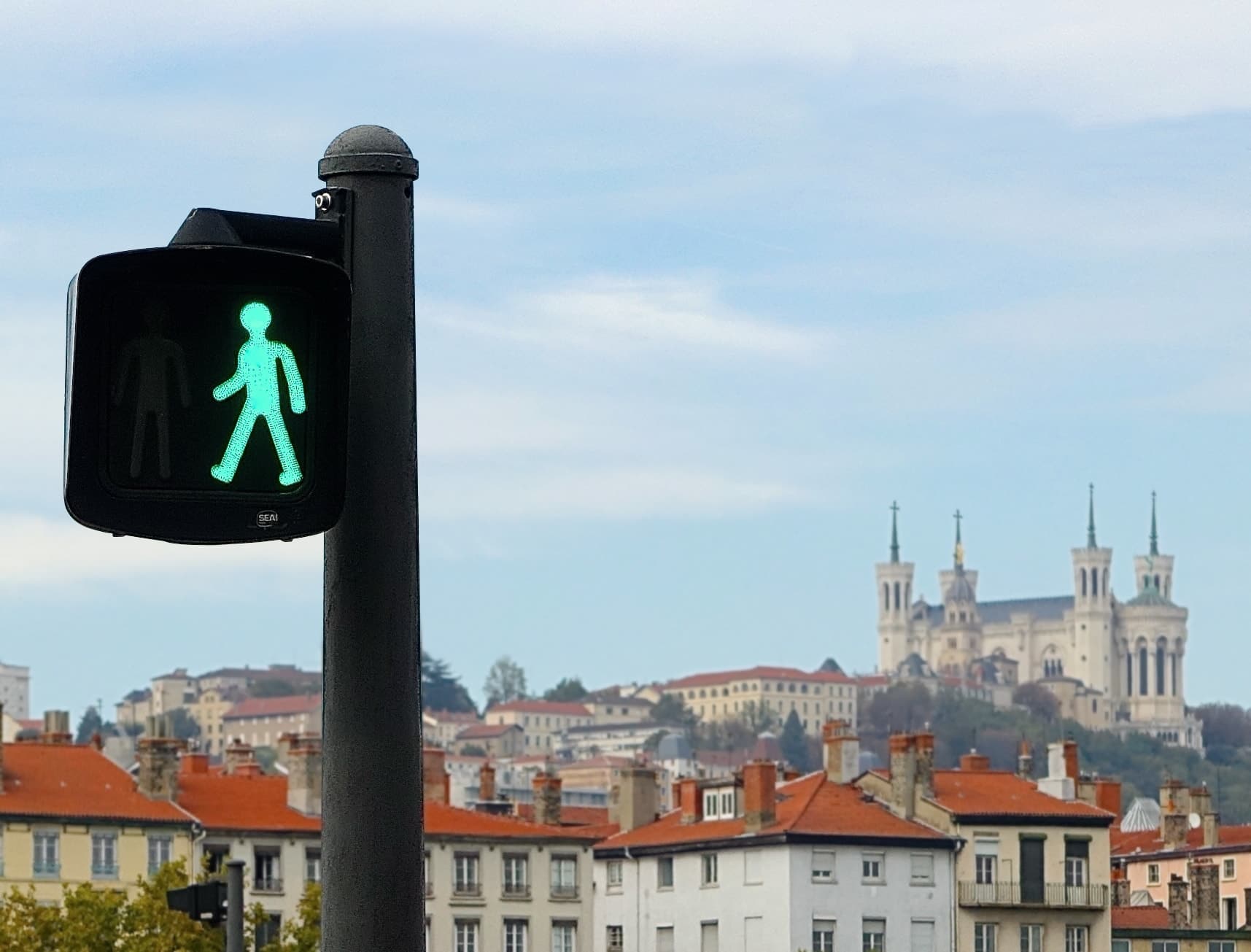 zoom sur une figurine piéton en phase verte, vue sur Fourvière