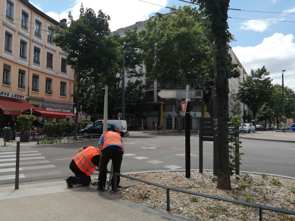 Deux techniciens de la métropole travaillent sur un mât du carrefour